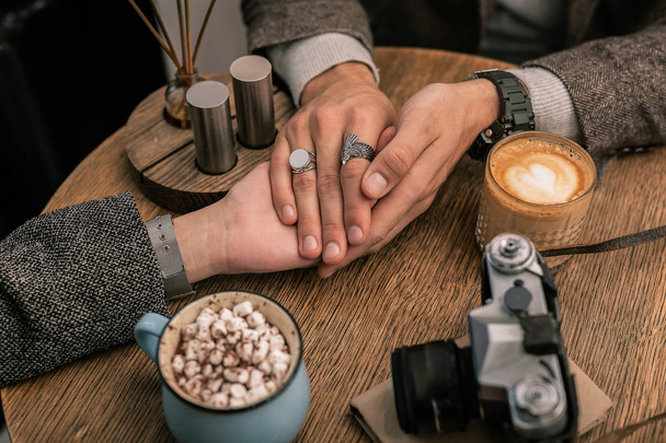 Man holding womans hands while sitting in a cafe - Foto, Imagem