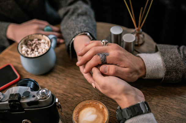 Man hands holding woman hands in a cafe - Fotó, kép