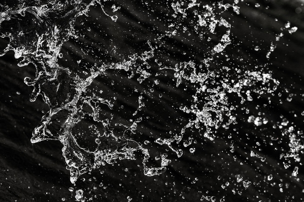 Wassertropfen in der Luft auf dunklem Bokeh-Hintergrund - Foto, Bild