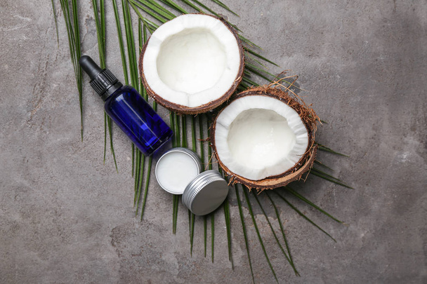 Flat lay composition with natural cosmetics and coconut on grey background - Fotó, kép