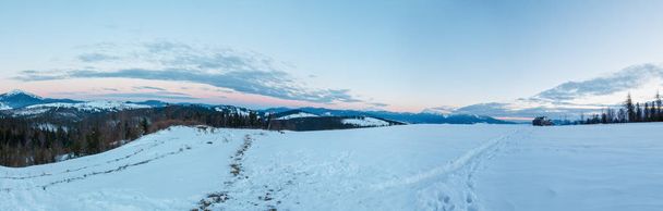 Evening twilight winter mountain ridge scenery panorama view through car windshield, Carpathian Chornogora and Gorgany Mountains. Beautiful vacation travel by car concept. Car model unrecognizable. - Foto, imagen