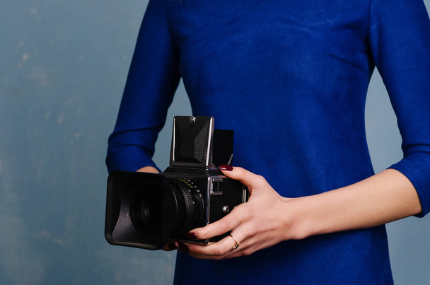 Girl in vintage blue dress holding old medium format camera. - Valokuva, kuva