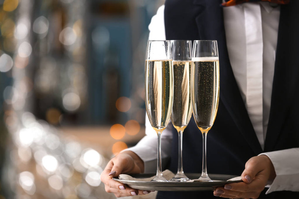 Camarera sosteniendo bandeja con copas de champán en la fiesta
 - Foto, Imagen