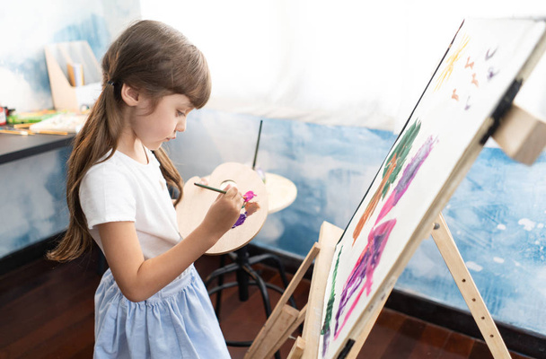 Šťastné veselé dítě kreslení štětcem v n plátno u ní doma. Koncepce vzdělávání v raném dětství, šťastná rodina, rodičovství - Fotografie, Obrázek