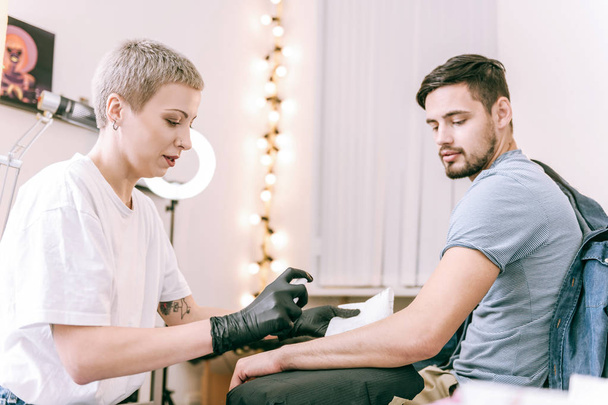 Accurate short-haired female master preparing surface of her client hand - Photo, image