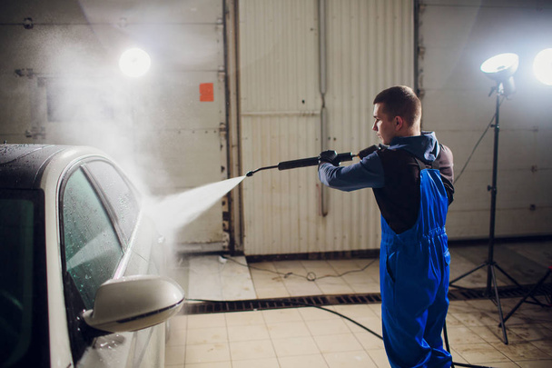 man washing automobile manual car washing self service,cleaning with foam,pressured water. Transportation care concept. Washing car in self service station with high pressure blaster - Photo, Image