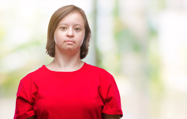 Mujer adulta joven con síndrome de Down sobre fondo aislado con expresión seria en la cara. Simple y natural mirando a la cámara
. - Foto, Imagen
