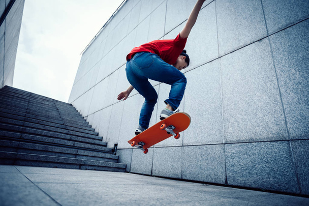 Young skateboarder doing ollie at city - Foto, Imagen