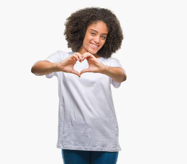 Young afro american woman over isolated background smiling in love showing heart symbol and shape with hands. Romantic concept. - 写真・画像