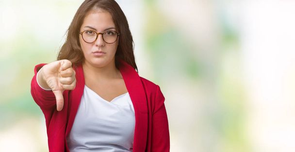 プラスサイズの若いビジネス女性美しい不幸なと怒って拒否反応を示さず、ジェスチャーを親指で否定的なバック グラウンドを分離でエレガントなジャケットとメガネを着用します。不適切な表現. - 写真・画像
