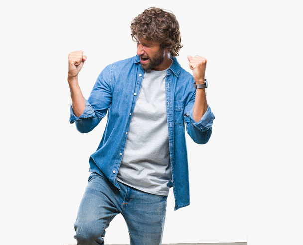 Handsome hispanic model man over isolated background very happy and excited doing winner gesture with arms raised, smiling and screaming for success. Celebration concept. - Photo, Image