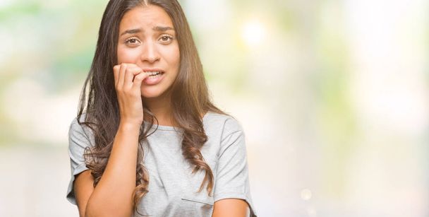 Young beautiful arab woman over isolated background looking stressed and nervous with hands on mouth biting nails. Anxiety problem. - Photo, Image
