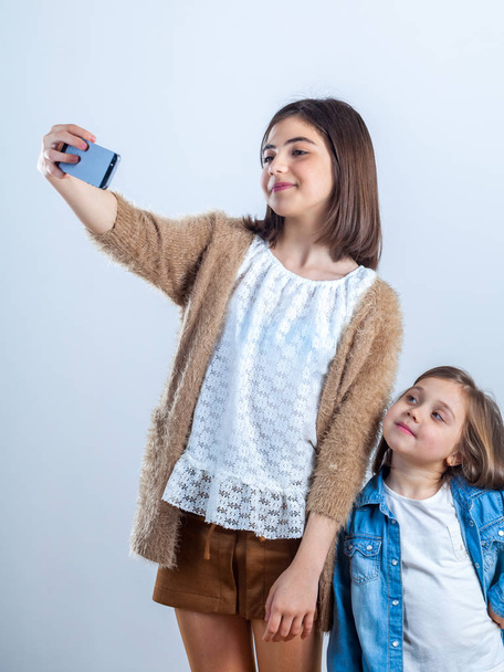 two sisters of different ages take a selfie in a photo studio. - Foto, Bild