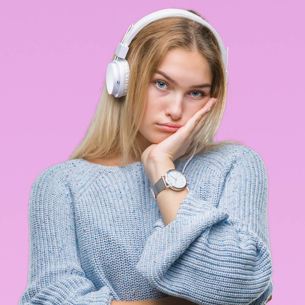 Young caucasian woman listening to music wearing headphones over isolated background thinking looking tired and bored with depression problems with crossed arms. - Photo, Image