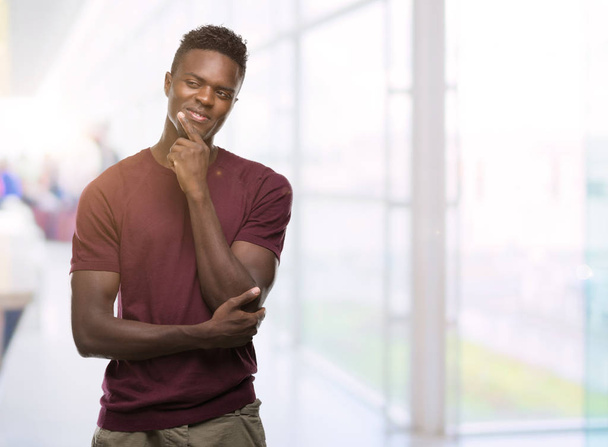 junger afrikanisch-amerikanischer Mann ernstes Gesicht über Frage nachdenkend, sehr verwirrte Idee - Foto, Bild