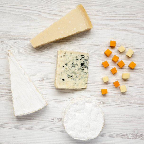 Various kinds of cheeses on white wooden surface, top view. - Photo, Image