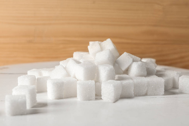 Куча очищенных кубиков сахара на столе
 - Фото, изображение
