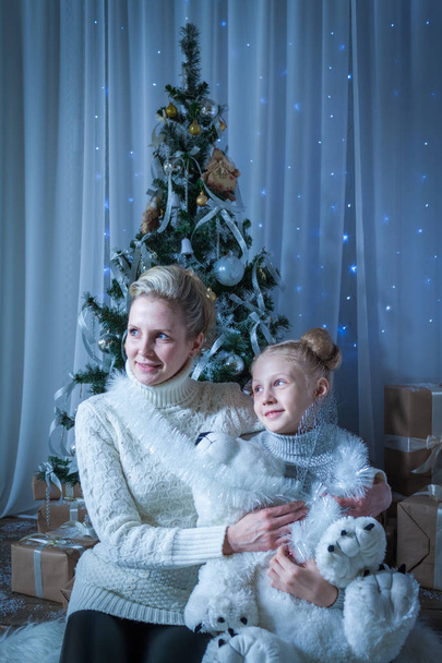 Bella donna e sua figlia vicino all'albero di Capodanno
 - Foto, immagini