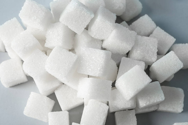 Un mucchio di cubetti di zucchero raffinati sul tavolo, primo piano
 - Foto, immagini