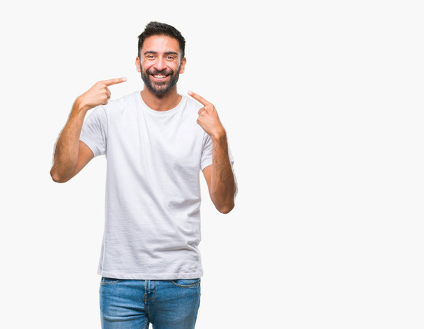 Hispánský muže izolované pozadí s úsměvem sebevědomá ukazující a ukazující prsty zuby a ústa. Koncepce zdraví. - Fotografie, Obrázek