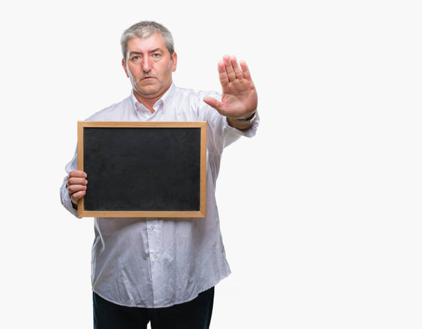 Bello anziano insegnante man holding lavagna su sfondo isolato con mano aperta facendo stop segno con espressione seria e fiduciosa, gesto di difesa
 - Foto, immagini