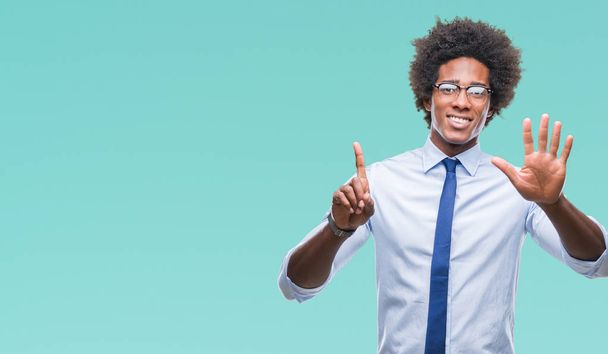 Afro americký obchodní muž nosí brýle nad izolované zobrazeným pozadím a směřující nahoru prsty číslo šest, zatímco s úsměvem a spokojené. - Fotografie, Obrázek