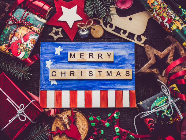 Greeting card with US Flag drawing, New Year and Christmas decorations, boxes with gifts on a brown surface. Top view, close-up, flat lay. Merry Christmas and Happy New Year - Foto, Bild