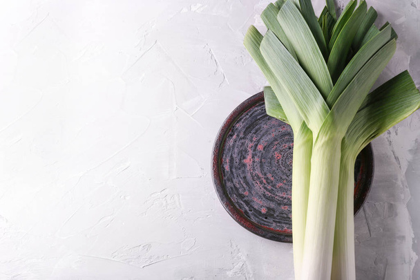 Plate with raw leeks on light table - Photo, Image