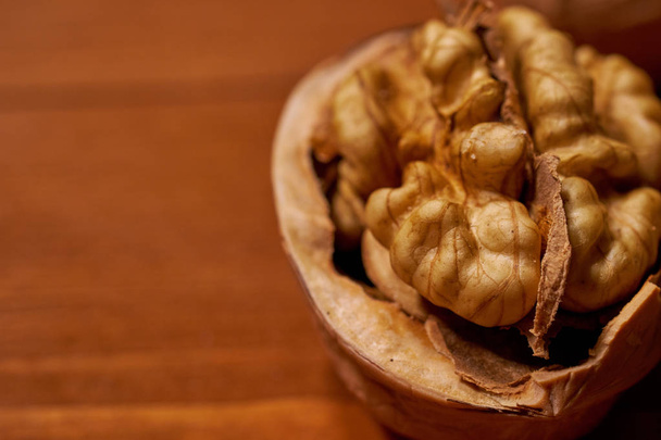 Walnut on brown wooden background.  - Фото, изображение