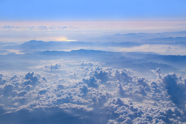 Voo acima das nuvens. Panorama maravilhoso da janela de avião com nuvens brancas. Voando sobre nuvens brancas. Nuvens brancas abaixo. Belo panorama com o céu
 - Foto, Imagem
