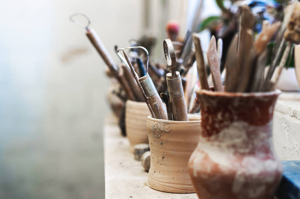 Close up photo of tools for ceramics work stand on window sill indoor workspace ready correct dishes or tableware form with copy space for text - Photo, Image