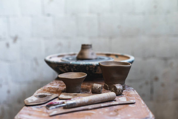 Photo of two small ceramics clay cup on table indoor old vintage workspace against blurred background - Foto, afbeelding