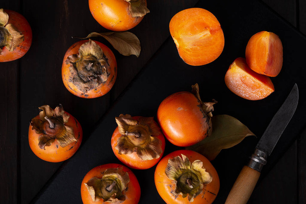 Хурма натюрморт в сдержанном ключе. Органические плоды каки, собранные осенью. Диезирос Каки. Top viw
 - Фото, изображение