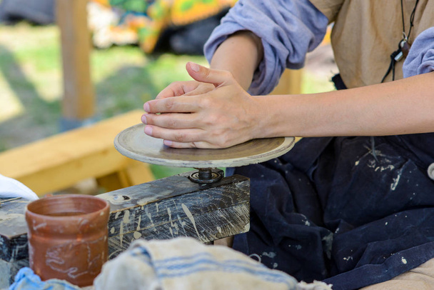 Mãos astutas trabalhando com argila em uma loja de cerâmica medieval
 - Foto, Imagem