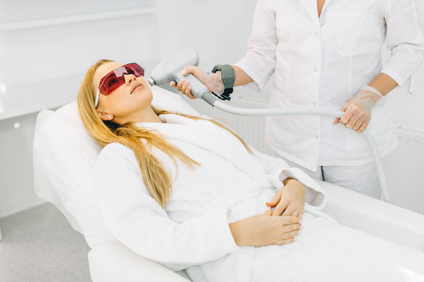 Woman getting laser and ultrasound face treatment in medical spa center - Fotó, kép