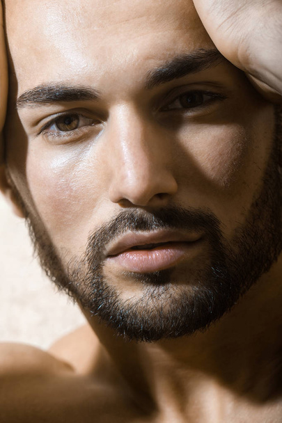 Male face. Attractive man. Handsome young man. Portrait of a sexy guy. Confident look. Men's fashion. Beautiful face of a young bearded man - Foto, imagen