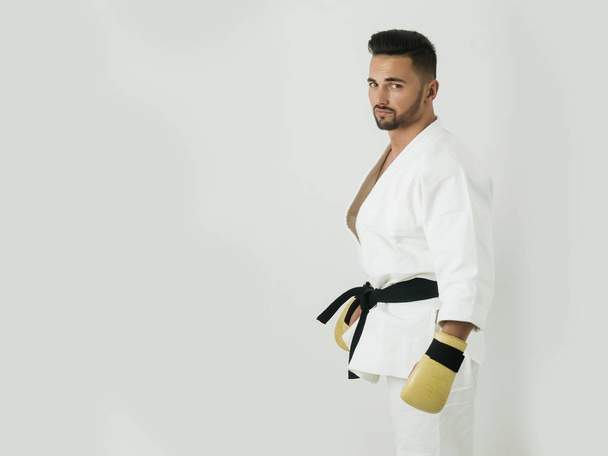 Un atleta atractivo aislado sobre fondo blanco. Hombre guapo en chándal para boxeo o karate. Gimnasio y entrenamiento deportivo, entrada de entrenamiento
 - Foto, Imagen