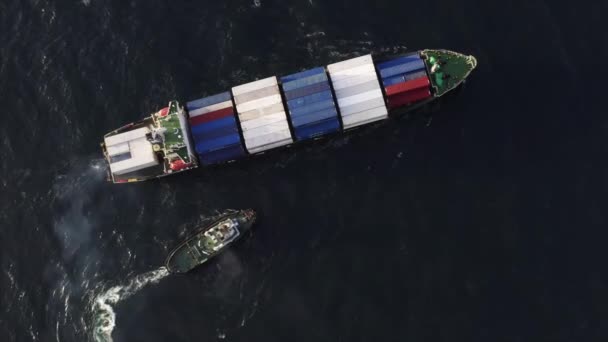 Top aerial view of cargo ship with colourful containers arrived in russian port and small motor vessel trying to moor alongside it - Footage, Video