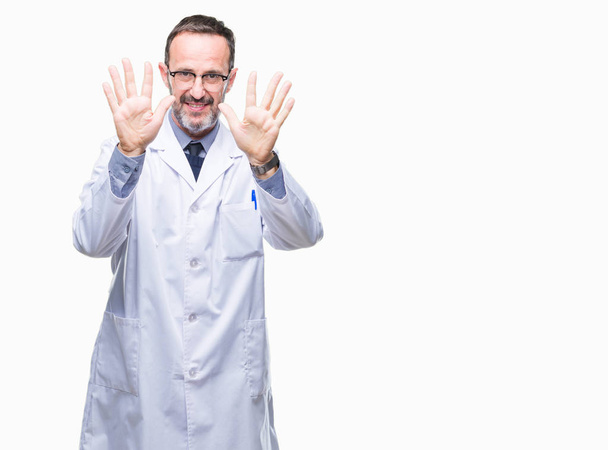 Homme professionnel sénior d'âge moyen portant un manteau blanc sur fond isolé montrant et pointant vers le haut avec les doigts numéro dix tout en souriant confiant et heureux
. - Photo, image