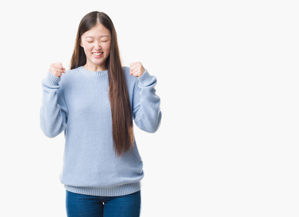 Giovane donna cinese su sfondo isolato eccitato per il successo con le braccia sollevate celebrando la vittoria sorridente. Concetto vincitore
. - Foto, immagini