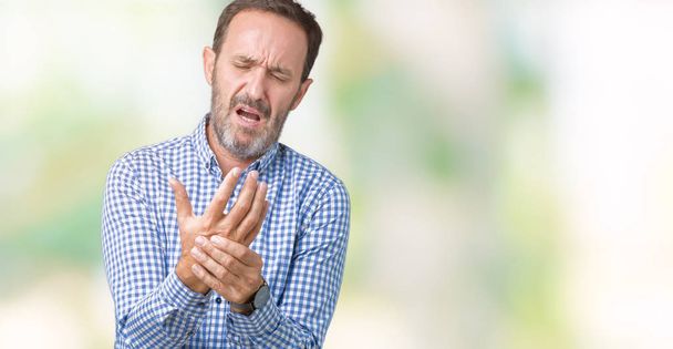 Красивий середнього віку елегантний старший чоловік над ізольованим тлом Страждаючий біль на руках і пальцях, запалення артриту
 - Фото, зображення