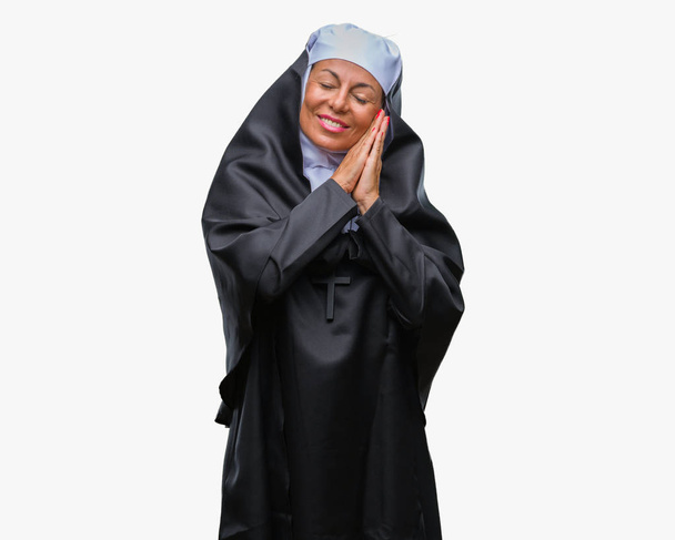 Moyen Age senior chrétienne catholique nonne femme sur fond isolé sommeil fatigué rêver et posant avec les mains ensemble tout en souriant avec les yeux fermés
. - Photo, image