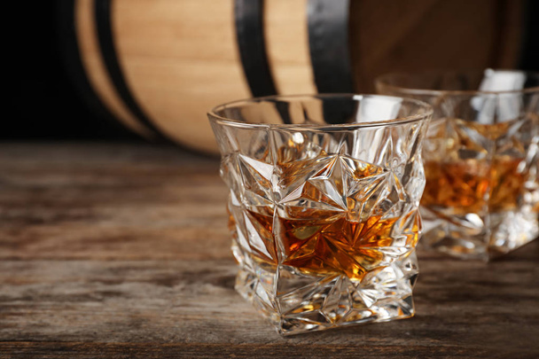Golden whiskey in glass with ice cubes on wooden table. Space for text - Fotografie, Obrázek