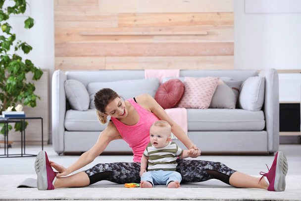 Young sportive woman doing exercise with her son at home. Fitness training - Foto, imagen