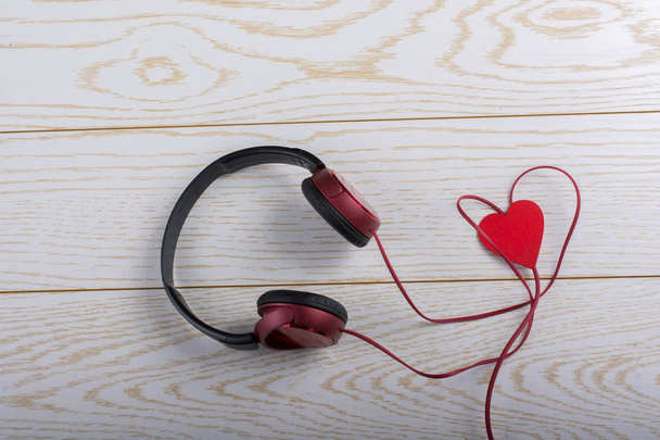 Red heart and red headphones on a wooden background - Fotografie, Obrázek