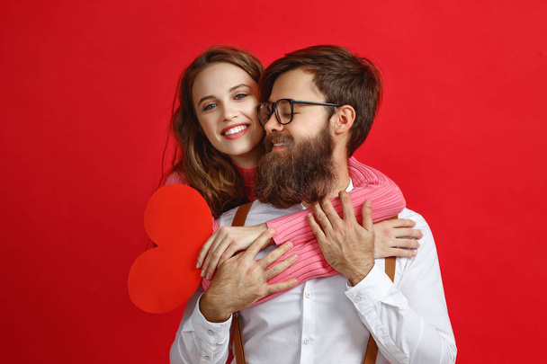 valentine's day concept. happy young couple with heart, flowers, gift on red background - Photo, Image