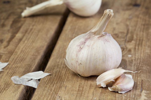 Organic garlic whole and cloves on the wooden background - Фото, зображення