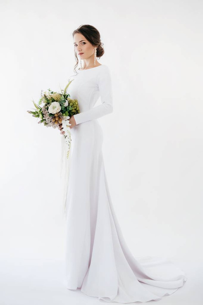 schöne junge Braut im weißen Brautkleid posiert im Studio - Foto, Bild