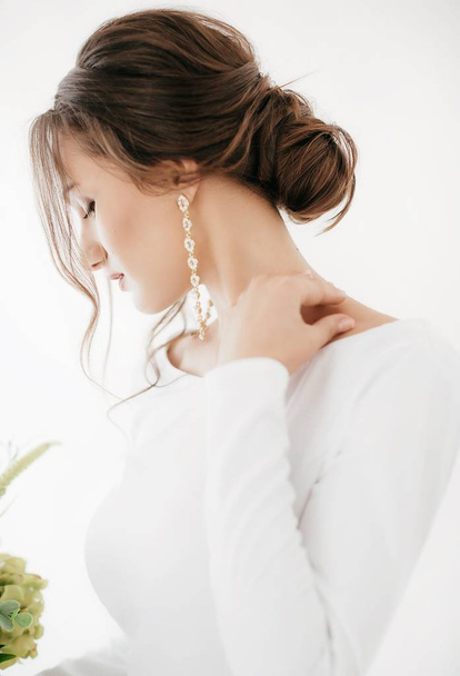 花とポーズが白いウェディング ドレスで美しい若い花嫁 - 写真・画像