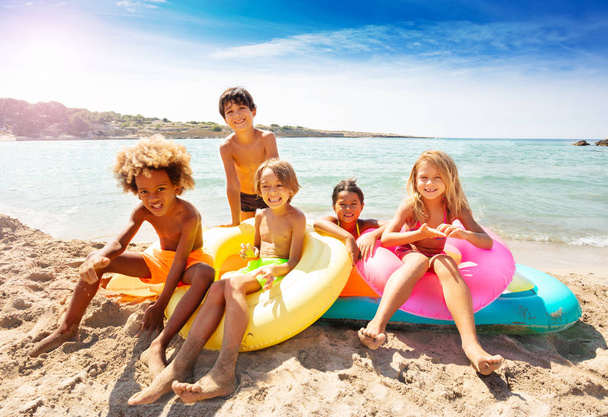 多民族の子供たち、幸せな男の子と女の子、海辺で膨脹可能なマットレスの上に座っての大きなグループ - 写真・画像